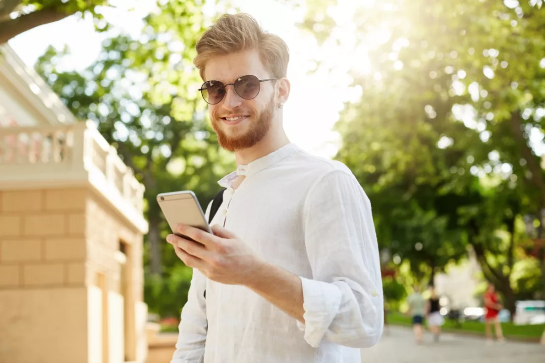 Mladý muž kontroluje svůj profesní profil v telefonu